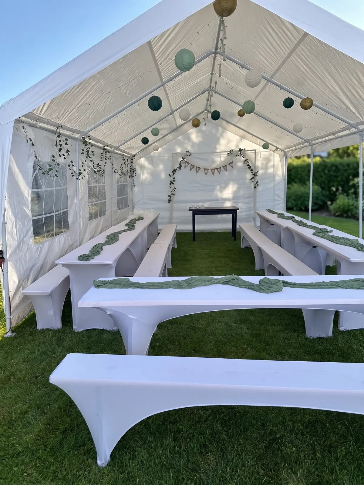 Bierzeltgarnituren mit weißen Stretch-Hussen und salbeigrünen Tischläufern im Festzelt