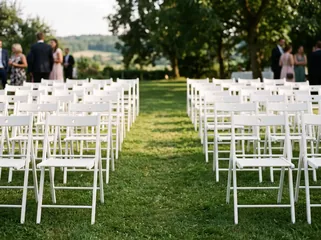 Weiße Holzstühle bei einer Hochzeit im Freien